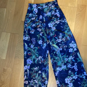 Super söta byxor 💜 - Fina, tunna, vida byxor med hög midja och hel långa ben. Byxans bredd i midjan är 34 cm med resår bak. Längd fr midja linning är 106 cm. 