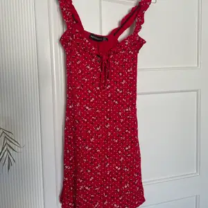 Rödblommig klänning från Pretty little thing  Aldrig använd 