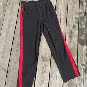 Kostymbyxor  - Kostymbyxor mer röda streck på båda sidorna. Snörning i midjan och resor där bak.