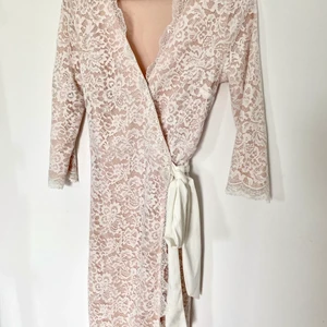 Klänning spets - Superfin sommarklänning med vit spets och beige-rosa underklänning i stl. S. Endast använd 1 gång så den är som ny. Frakt tillkommer men kan även mötas upp i Stockholmsområdet.