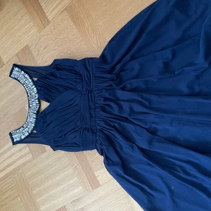 Festklänning  - Marinblå tyllklänning med broderier och underkjol. Slutar stax ovanför knäna och v-ringad i ryggen.  Skriv om du vill ha bild av hur plagget ser ut på! 