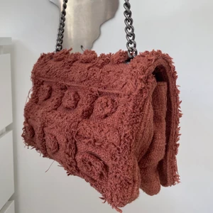 Vinröd handväska  - En vinröd handväska med två fack och ett lite längre axelband. 