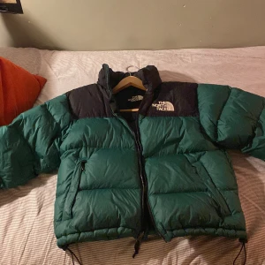 Northface Puffer  - Grön northface jacka, använd en vinter och i bra skick förutom ett litet hål på ryggen. Storleken är M men passar även S. Tvättar jackan innan den skickas, pris kan diskuteras