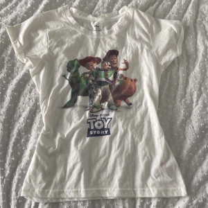 Graphic T-shirt  - Vit tshirt med Toy story tryck. Står ingen storlek men skulle nog passa många beroende på hur man vill att den ska passa. Läs bio för mer info