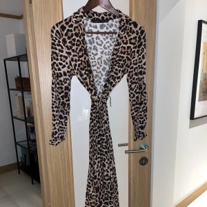 Zara klänning i leopardmönster - Jättefin leopardmönstrad klänning från zara i stl XS. Knäpps med knappar och ett knytband i midjan. Midi-lång
