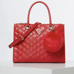 Exklusiv Röd Guess väska i modellen Astrid luxury satchel som inte säljs längre och är svår att få tag på. Använd två gånger, axelrem samt dustbag ingår. Köpt för 2 000kr.
