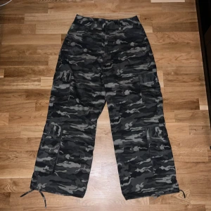 Baggy camoflague cargos - Säljer dessa skit feta cargobyxorna pga dem inte passar mig vid midjan. Dem har fickor vid sidorna och små snören vid ändorna som man kan knuta för att göra ändorna tightare osv. Byxorna är från ASOS - Collusion och storleken är W30 L30