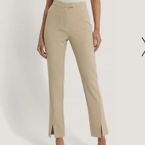 Kostymbyxor  - Beiga kostymbyxor från na-kd. I fint skick och sitter så snyggt på. De går ner till fötterna på mig som är 161cm🥰 köparen står för frakt!