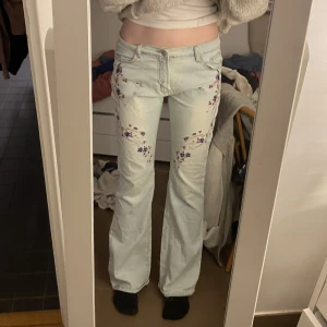 Lågmidjade jeans med tryck - Ljusa lågmidjade jeans med blommor på. Långa!  Supersnygga men kommer aldrig till användning:( Midjemåttet är 80cm 