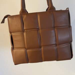 Brun handväska från märket ”Stockh lm”. Cirka 35x25 cm. Finns en längre rem.