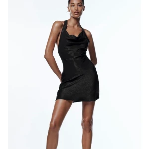 Slutsåld klänning från Zara  - Säljer denna perfekta klänning till nyår. Klänningen är i silkigt svart material med små glitterkorn in. Dragkedja i sidan och man knyter banden runt halsen så man kan justera urringningen. Klänning är slutsåld på hemsidan i alla storlekar utom L. Helt ny med lapparna kvar. 