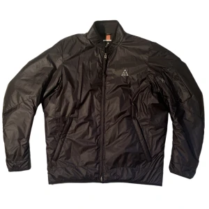 Nike LAB ACG bomber - Märke: Nike LAB All Conditions Gears (ACG) Modell: Nike LAB ACG Bomber Storlek: M Färg: Svart Skick: Använd utan större slitage Information: Deadstock som ej går att köpa längre. https://www.tradera.com/item/1000694/576431941/nike-lab-acg-bomber