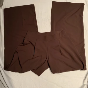 Bruna kostymbyxor  - Bruna kostymbyxor från Nelly. I toppskick då de endast har används för provning. Tyvärr för små för mig som brukar ha M i byxor:( Superskönt material och fin färg❤️