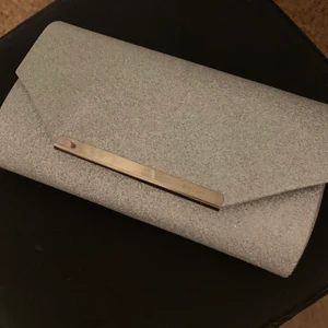 Silvrig väska - En perfekt väska nu till alla som ska gå balen! I super bra skick och band medföljer om man vill ha den runt axeln!