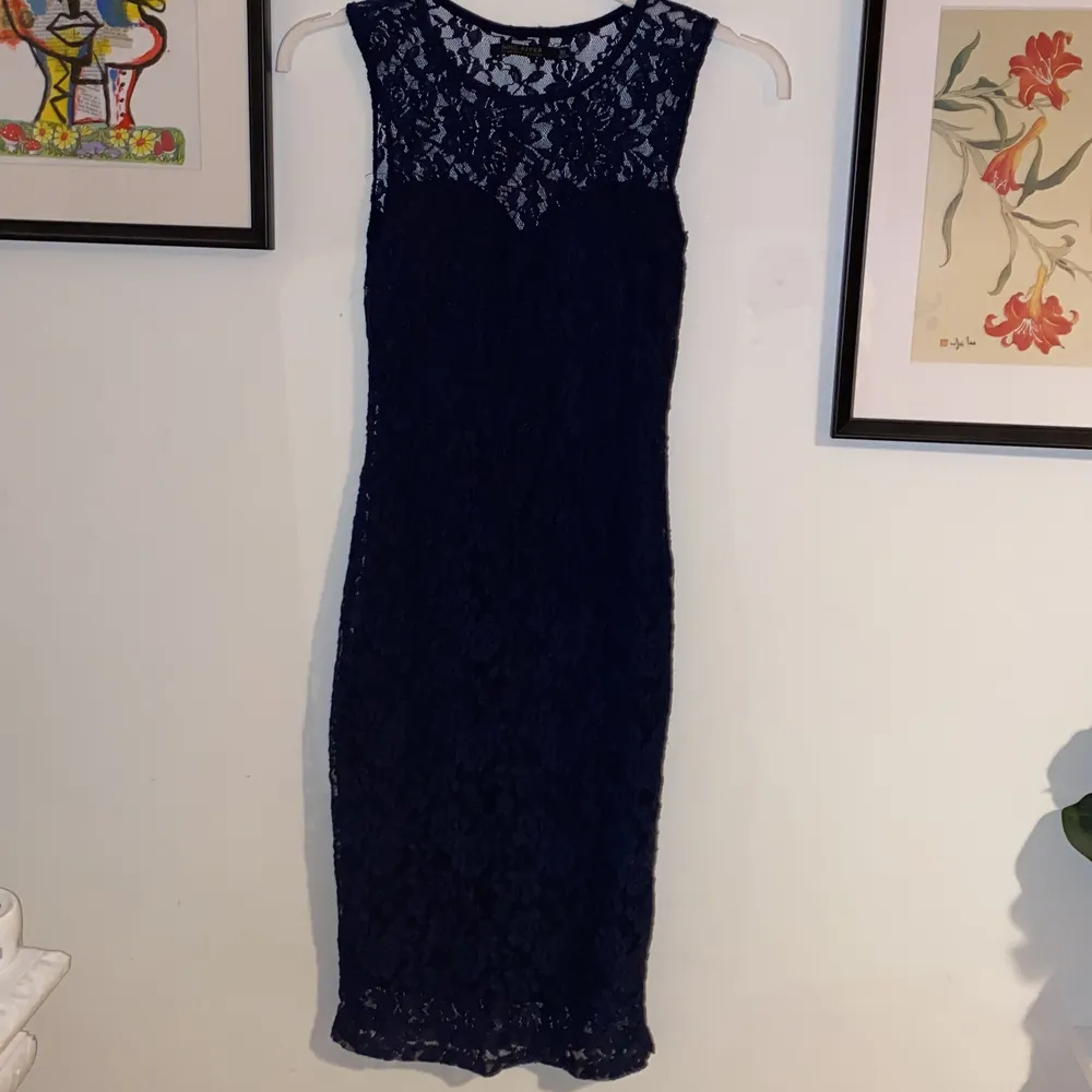 En klänning i mörkblå vacker spets, aldrig kommit till användning eftersom den är för liten för mig, men om jag hade kunnat haft den hade jag lätt haft på mig den!! Så snygg verkligen, wow. Klänningar.