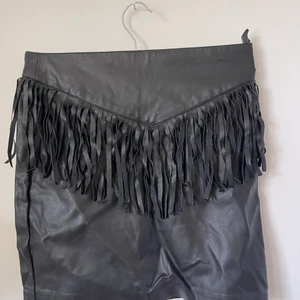 Kjol - Svart skinn kjol med fransar, använd fåtal gånger men har bara legat i garderoben senaste åren (därav skrynklig) 