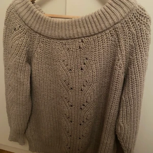 Stickad tröja i rosa/beige - En stickad tröja i en rosa/beige färg. Den går att ha både över axlarna och nedanför axlarna. Den har en fin detalj över hela tröjan som är ett fint mönster av små hål. Är i storlek XS och säljes för 100kr👚