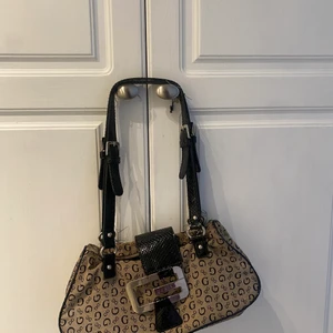 Vintage, fake Guess handväska - Säljer världens finaste väska pågrund av behov av pengar. Passar till allt, i gott skick och är super snygg!