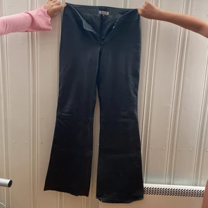 Svarta skin byxor  - Dessa är min mammas gamla byxor från 90-talet. Skin byxor, välanvända, lite slitna. Priset är ink frakt. Storlek 38. Innerbenslängden är 82