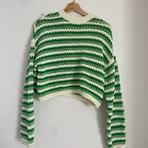 Grön hålstickad sweatshirt - Grön och beige hålstickad sweatshirt köpt för 359kr från pull&bear. Storlek S och endast använd en gång! Säljer för 200kr. Kan skicka fler bilder på plagget!