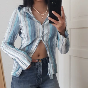 Blå randig skjorta - Blå randig skjorta med lite tajtare passform på mig som bör S. ÄLSKAR de utsvängda ärmarna och att man ksn knäppa upp och ner hur man vill så det blir som flera toppar o stilar i en! Säljer bara om bra bud :) Strl på tröjan är 40, men jag brukar ha 36!