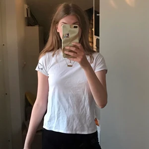 Vit t-shirt med ett hjärta 💘 - Vit t-shirt med ett hjärta på vänster ärm. Hög nacke & fittad kroppsform. 