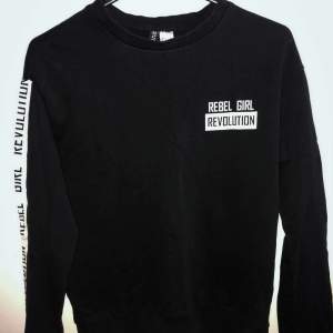 Enkel svart sweatshirt med text ”rebel girl revolution” från HM divided