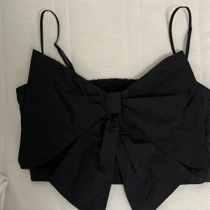 Svart Topp - Superfin svart topp med en rosett, ej använd pga den inte kom till användning, Den är strl 34🖤