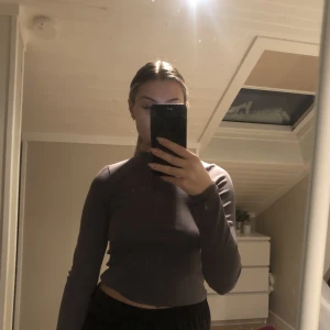 grå tröja med dragkedja - grå croppad tröja med dragkedja från Nelly i storlek 36.  endast använd 1 gång och säljer för att den inte kommer till användning, köparen står för frakt 🤍