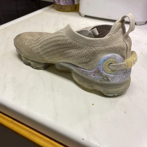 Nike air vapormax 2020 - Strl:40 Skorna är ett år gamla och dom är använda väl. Det är ett litet hål i tyget som syns på bilden. Det är smutsfläckar som inte går bort. Finns inget kvitto eller skolåda.
