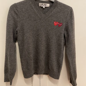 Cdg tröja - Cdg tröja i ull. Storlek S.  Använd sparsamt men dock ett hål vid baksida arm på höger sida, Som ni ser på bild 2. Ny pris ungefär 2000 kr.