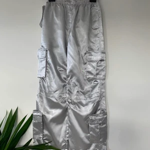 Silver cargo byxor  - Lågmidjade Y2K metallic cargo byxor. Så coola byxor i satin. Midjan kan justeras. Storlek är age 13yr❤️ 