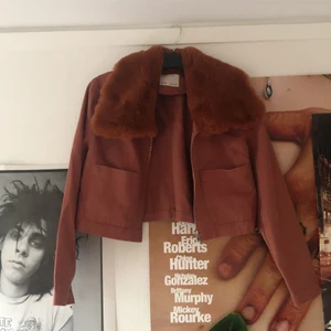 Jacka med fuskpäls - Svinfin croppad jacka med len fuskpäls i rostbrun! Ganska tunn, dragkedja samt två framfickor. Endast använd en gång. 