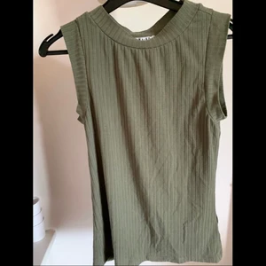 Grönt linne - Olivgrönt ribbat linne från nakd i strl xs. Använd fåtal gånger🤍