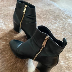 Svarta Stövletter  - Svarta stövletter med guld kedja, knappt använda storlek 38. 