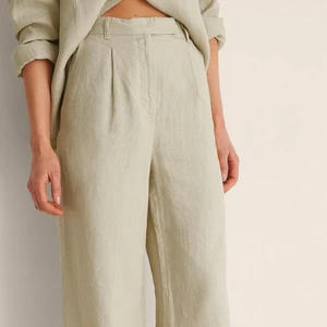 Linnebyxor med vida ben från NAKD - Den här byxan har en hög midja med en dragkedje- och knappstängning och hällor, två snedställda sidofickor på framsidan, två fuskbakfickor och vida ben. 💞 Jag köpte dessa från NAKD och bara älskade färgen och modellen men tyvärr är de förstora och jag har ALDRIG kunnat använda dem. Hoppas att de kan komma till nytta hos någon annan, hör av er! Går att hämtas upp i Kalmar eller Karlskrona eller skickas men då tillkommer en fraktavgift💕 Ordpris är 659kr men jag säljer för endast 420kr