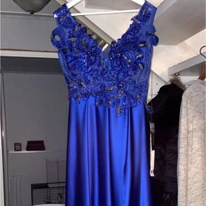 Fest/Bröllop/Bal klänning strl 44 - Snygg fest/bröllop/bal klänning i storleken 44. Den är ganska lång på mig som är 158 och blir som ett litet ”släp”. Endast använd 1 gång, Den har en snygg slits på vänstra benet och en underkjol med bra längd. Hör av om önskemål av fler bilder💕