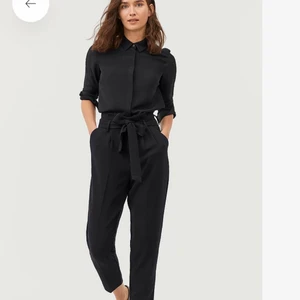 Kostymbyxor - Klassiska kostymbyxor i paper bag modell. Exakt samma modell som på bilden (var svårt att ta egen bild eftersom de är svarta). Knappt använda. Sitter tight över rumpan och lite lösare längs benen. Kolsvarta. Strl 34 men passar 32-36.