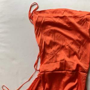 Orange långklänning med snörning bak. Oanvänd pga fel storlek. Passformen är jättefin men behövs underklänning pga lite genomskinligt tyg. 
