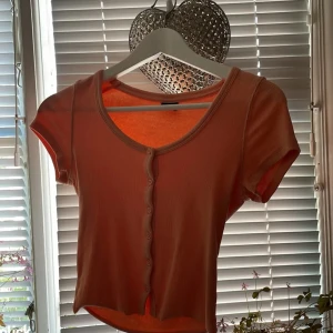 Peach färgad topp🍑 - Peach färgad ribbad topp med knappar i mitten som är oanvänd och kommer ifrån Gina tricot🥰