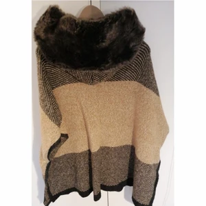 Zipkofta (poncho) med luva - Mysig och varm zip poncho i ull. I väldigt bra skick och har en stor luva med päls. Jättemysig till hösten och vintern. Säljer då jag tyvärr inte får mycket användning för den 😊🌸