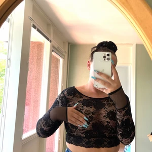 Fest-topp - Genomskinlig tunnare fest-topp med mesh runt handlederna och djup urringning i bak.