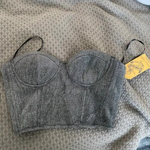 Glittrig korsett topp  - Super fin och helt ny korsett top som är perfekt till fest eller när man vill känna sig extra fin. Toppen är i storlek M men passar även de med S.