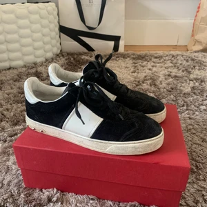 Svarta Valentino sneakers - Valentino sneakers i storlek 39. Passar mig som är storlek 38 också.  En av skorna har dessvärre tapppat två nitar, annars väldigt sparsamt använda. Låda och påse kommer med.