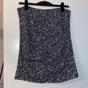 Rouched skirt - Svart/vit kjol. Rouched fram och bak, resår i midjan, väldigt stretchigt material. Strl 42, använd en gång.
