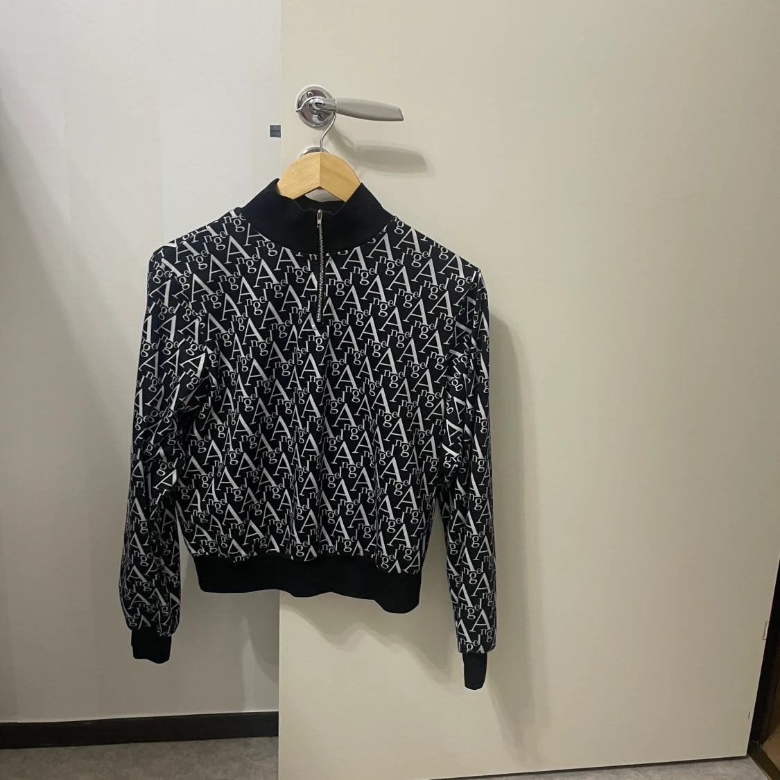 Svart vit tröja med ordet ”Angel” skriven runt hela tröja 