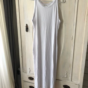 Oanvänd lång vit ribbad sommarklänning  - Helt oanvänd lång vit ribbad klänning från HM. Strl L men passar större o mindre beroende på hur man vill att den ska sitta. Är en tight modell men köpte större strl för att ha den lösare. 