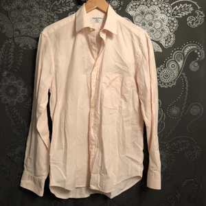 Valentino skjorta Vintage - En Klassisk rosa Valentino skjorta i storlek 40 som motsvarar M. Den har även en fick vid vänstra delen av skjortan med det klassiska ”V”.  OBS som man ser i bilden så är skjortan ej struken vilket förklarar varför den är vrinklig annars är den i bra con, när man väl har strukt den