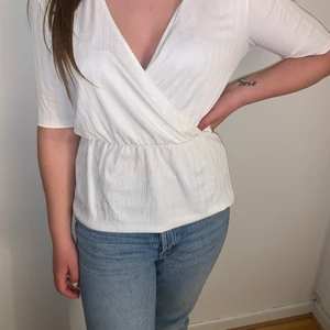 Vit blus  - Vit blus med v-ringad urringning med resor i midjan.