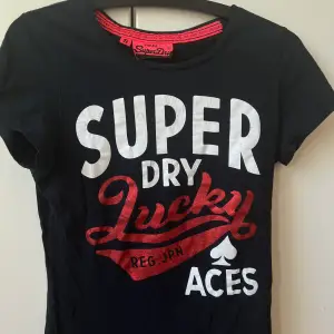 Denna snygga superdry T-shirt säljs nu för att den tyvärr inte längre kommer till användning. Den är svart med vit text. Samt att den röda texten är i glitter. Skriv för mer bilder 😊